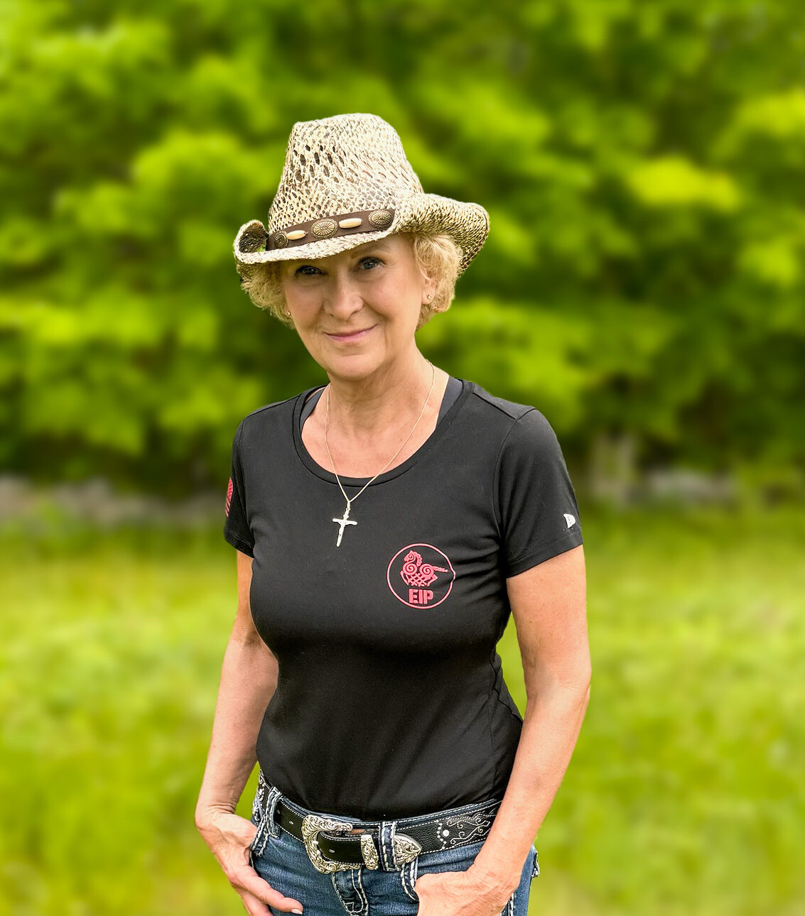 Female smiling wearing cowgirl hat and company apparel